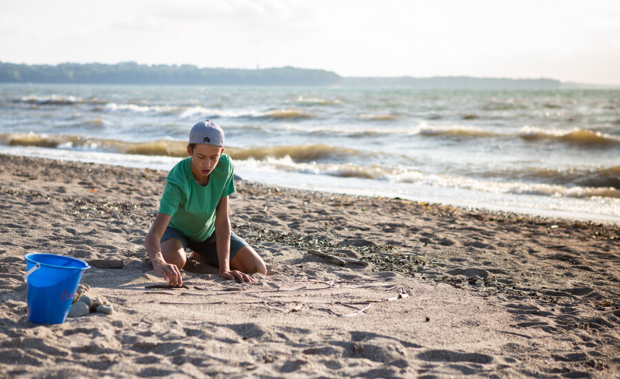 Boy playing in Hanover Beach sand 2019