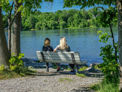 Two women sitting on a bench at Long Point State Park overlooking Chautauqua Lake