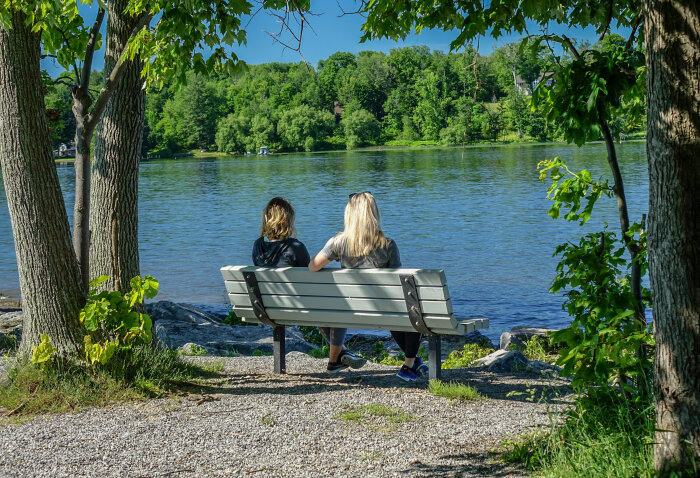 Two women sitting on a bench at Long Point State Park overlooking Chautauqua Lake