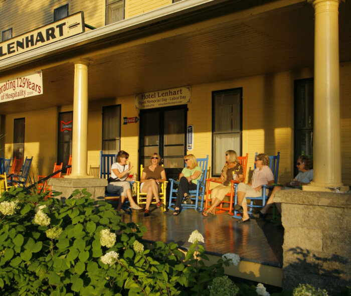 Five women sitting on the porch of the Glenhart Inn.