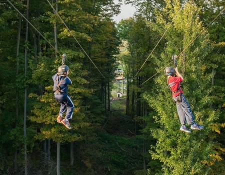 Two people on the zipline at Peek'n Peak Resort