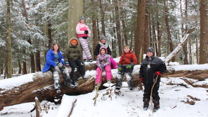 January Camp children in snowy woods at Audubon Community Nature Center