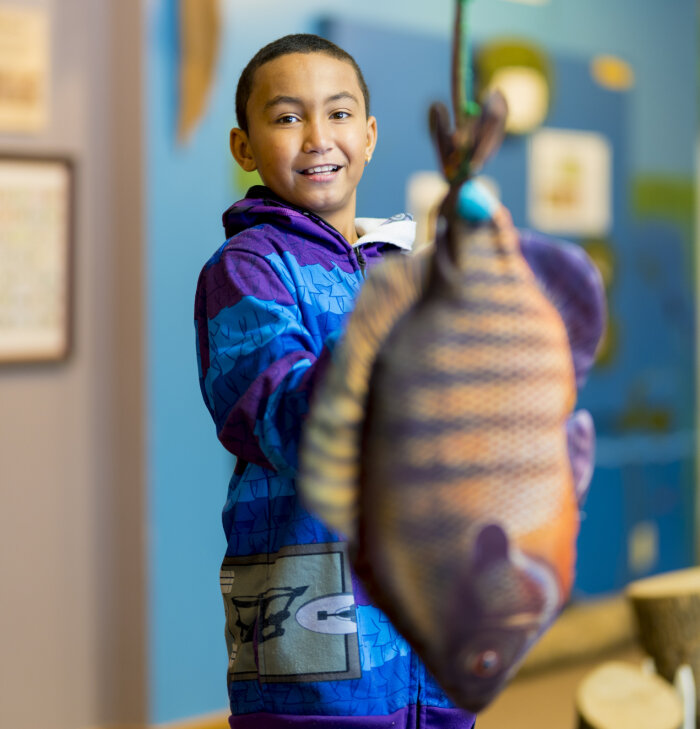 Child with fake fish at the Audubon Community Nature Center, Jamestown