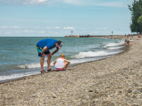 Barcelona Beach girl and dad looking for beach glass