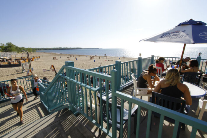 Lots of people visiting the beach on a sunny day.