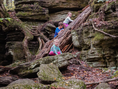 Three children climbing on a quartz formation at Panama Rocks Scenic Park