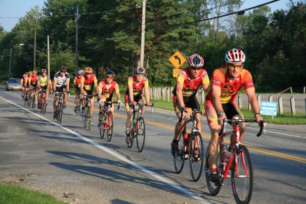 Several bike riders going down the road.