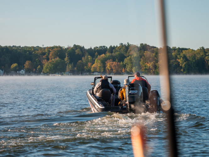 Three men on a boat on Chautauqua Lake, fishing