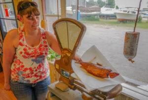 Woman holding a fish plaque.